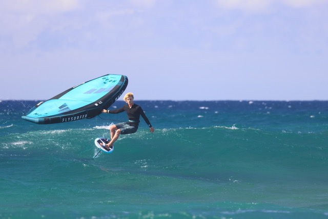 Wing surfer riding waves with Flysurfer wing foil on Cape Town ocean, Molo Africa Kite School